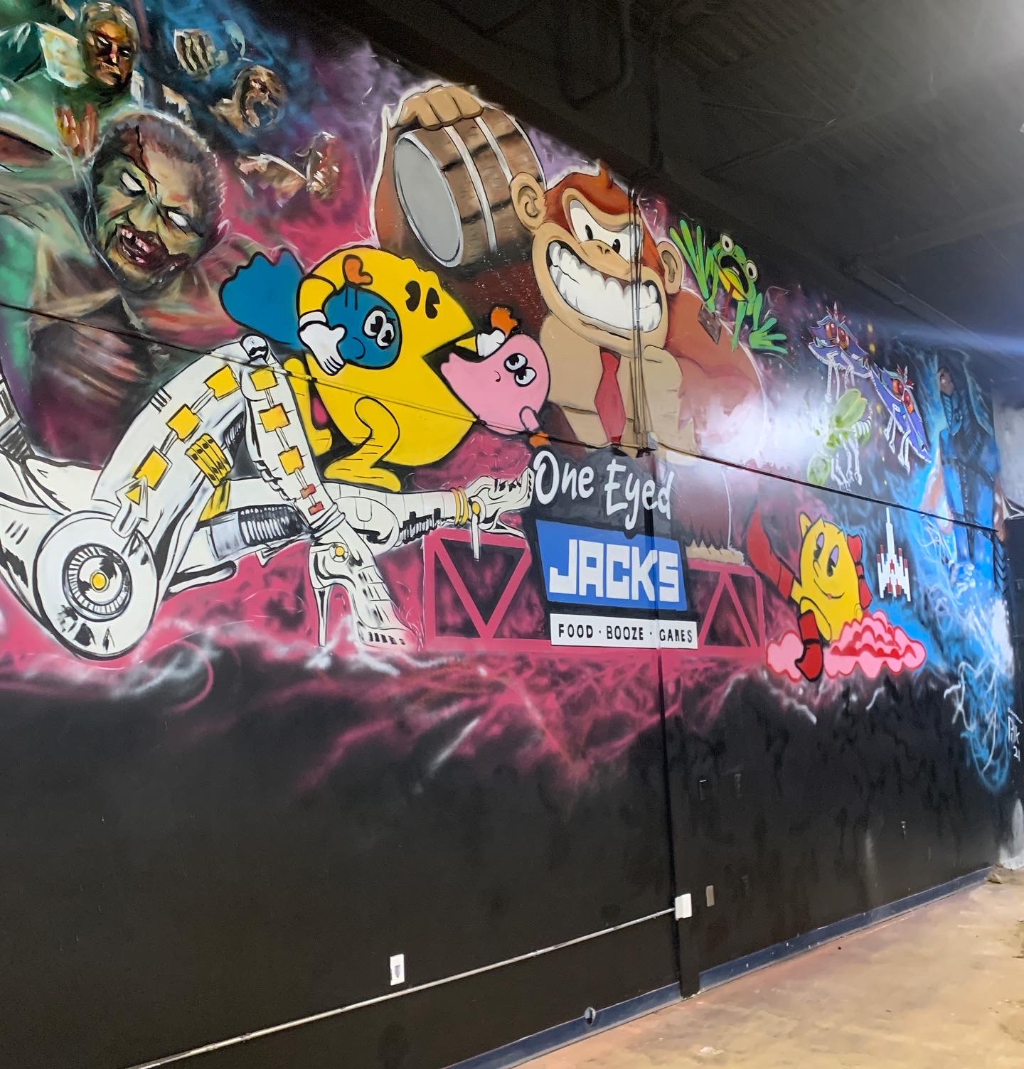 Bold colorful retro video game arcade mural featuring Pac-Man, Donkey Kong, Kirby and classic game characters for One Eyed Jacks