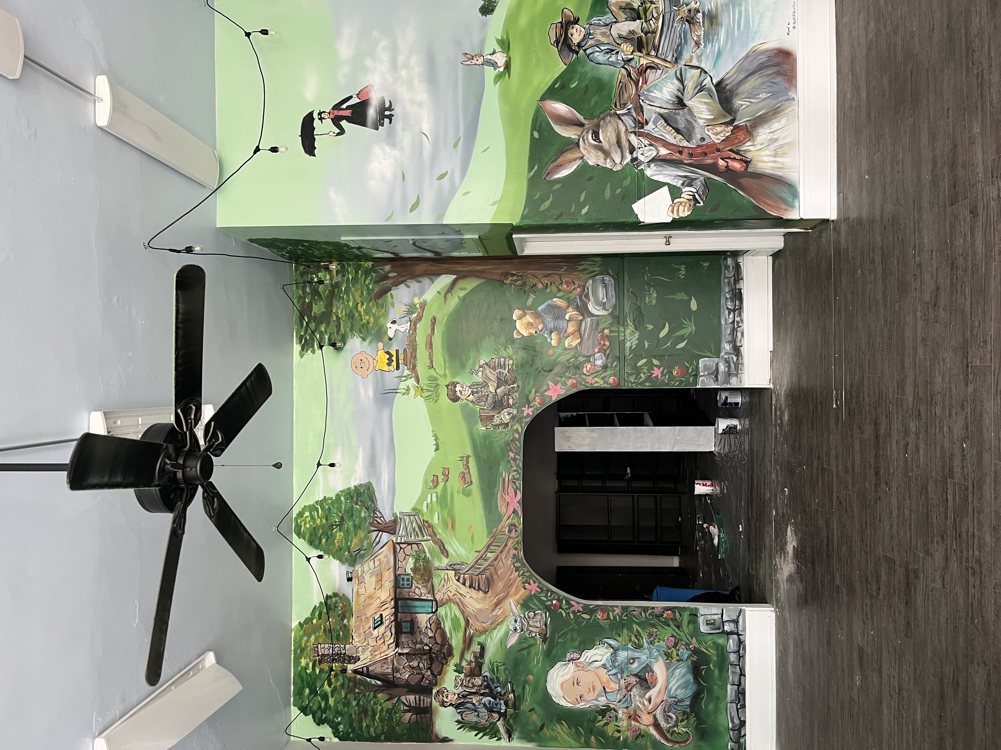 Whimsical detailed storybook mural with Charlie Brown, Snoopy, Winnie the Pooh and classic characters in green landscape